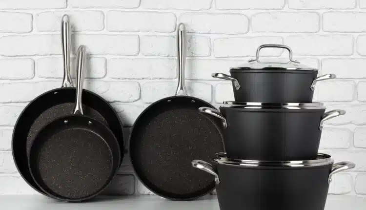 Set of cookware on table against white brick wall